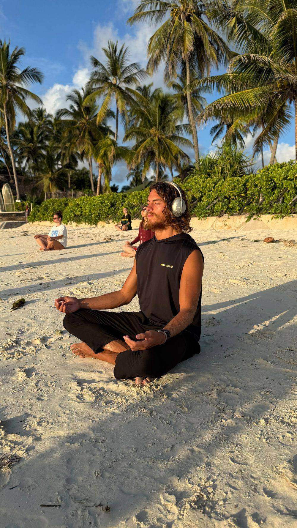 Giulio meditating on the beach at golden hour